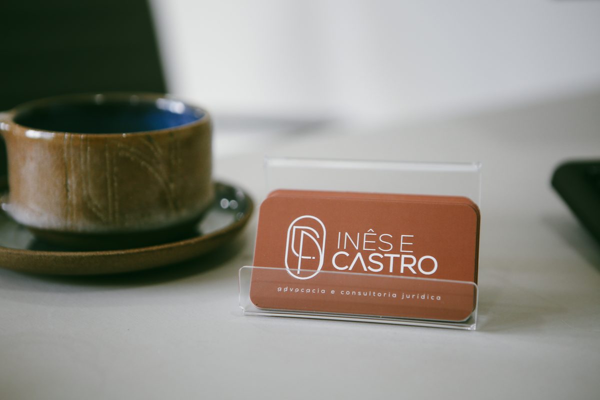 Cartões de visita Inês e Castro Advocacia ao lado de xícara artesanal