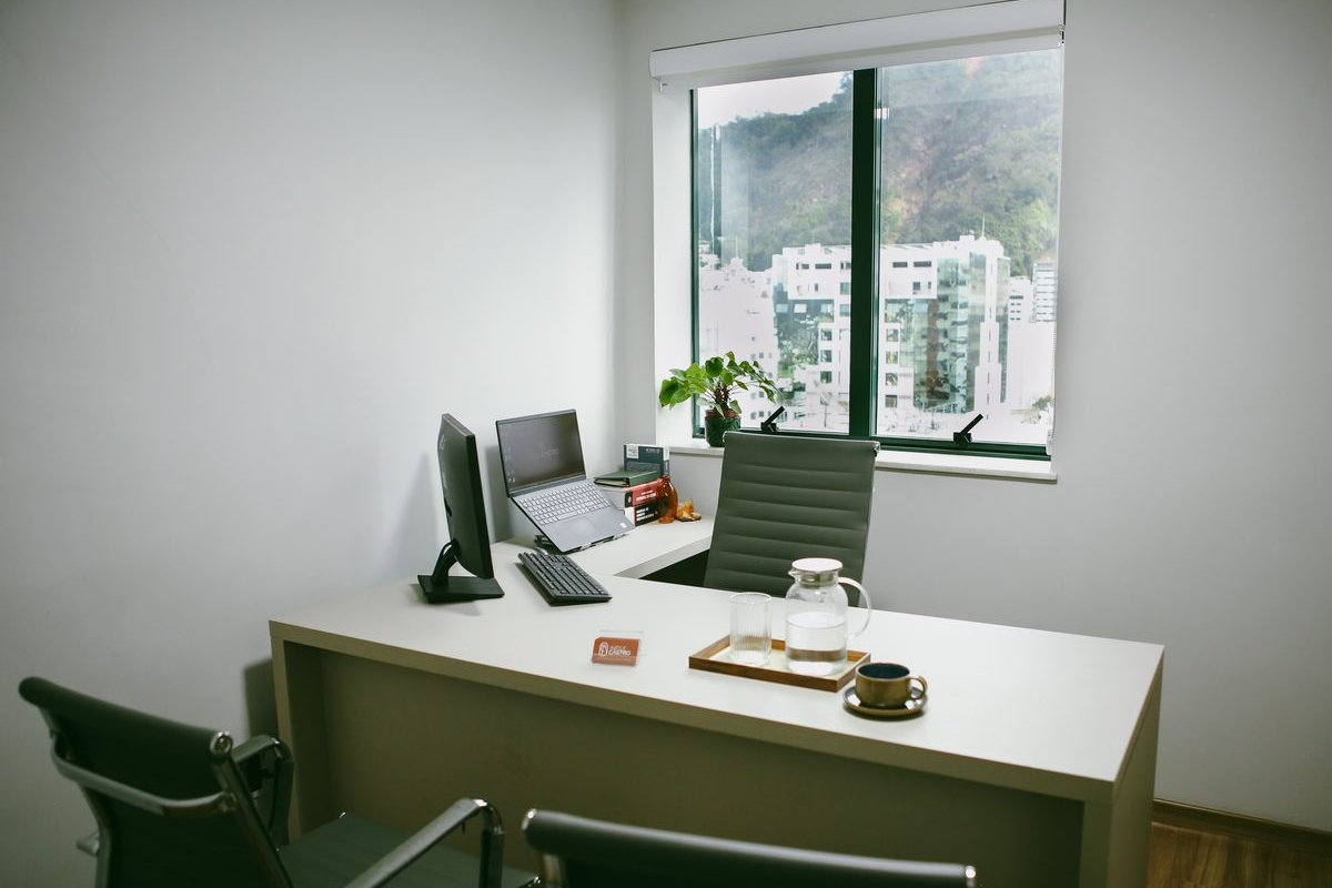 Mesa do escritório Inês e Castro com janela ao fundo